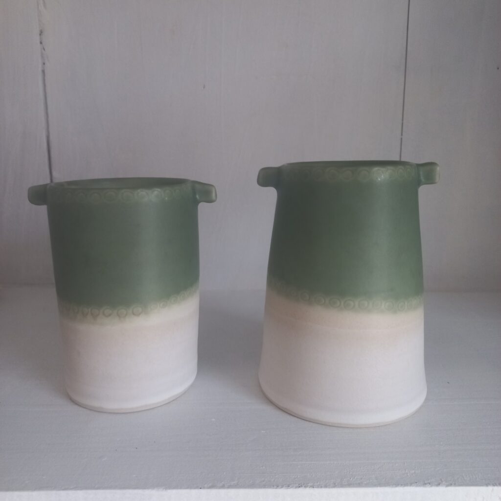 cette image montre 2vases bicolores vert et blanc avec des petites oreillettes sur les cotés