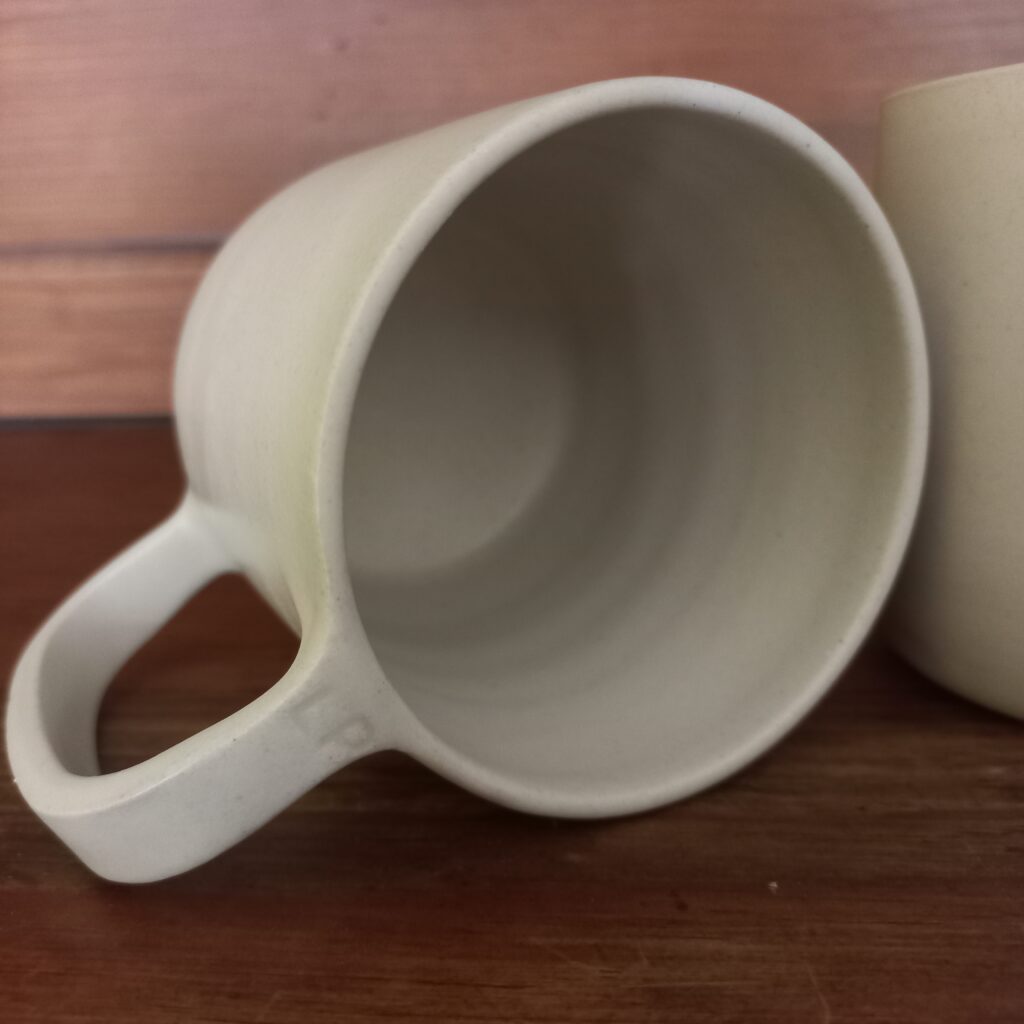 Cette image montre une tasse blanche entièrement unie en grès